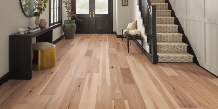 wood flooring in entry way with wooden bench and entryway table.